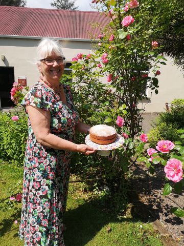 Mrs Suitor holding a cake and smiling